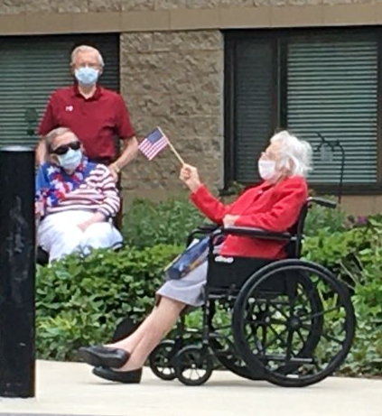 resident in a wheelchair waving an American flag